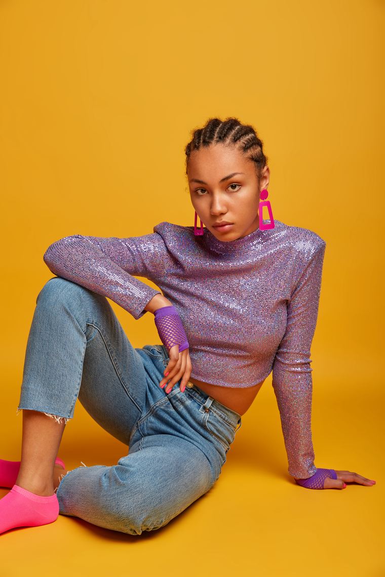 MAPS Studio model in a purple sequin top against a yellow studio backdrop