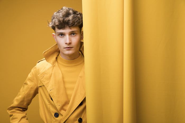 Male model in an editorial portrait on a yellow set